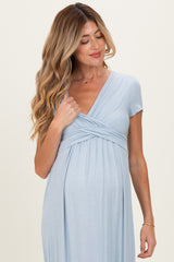 woman wearing a light blue short sleeve maternity dress with a ruched bust and a visible baby bump
