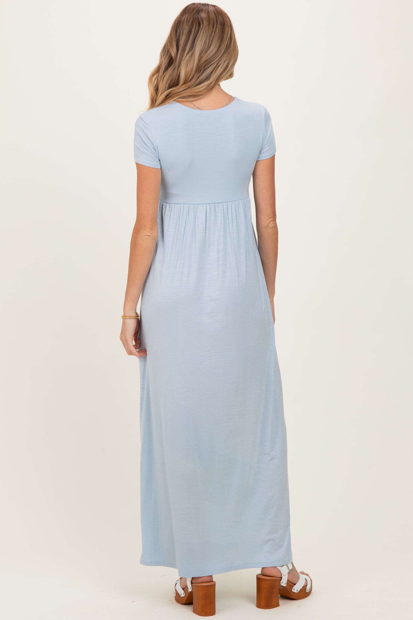 woman wearing a light blue short sleeve maternity maxi dress with a gathered waist and sandals