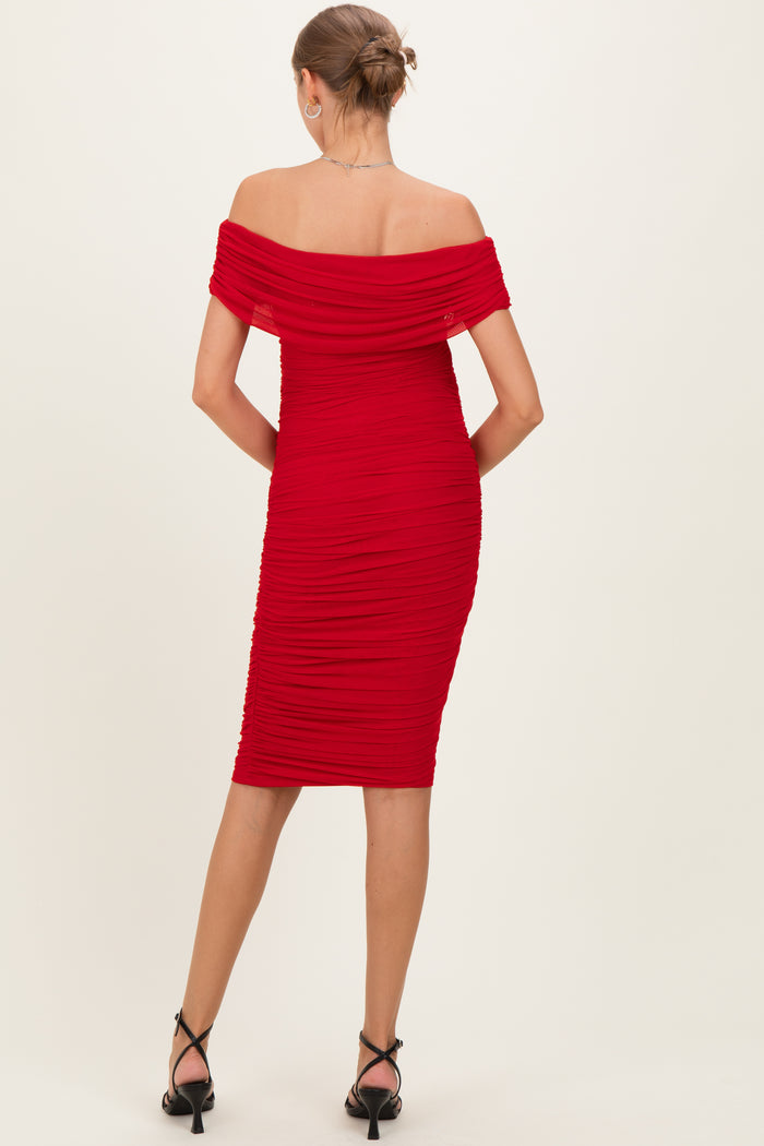 woman wearing a red off-the-shoulder ruched maternity dress, showing a fitted silhouette from the back