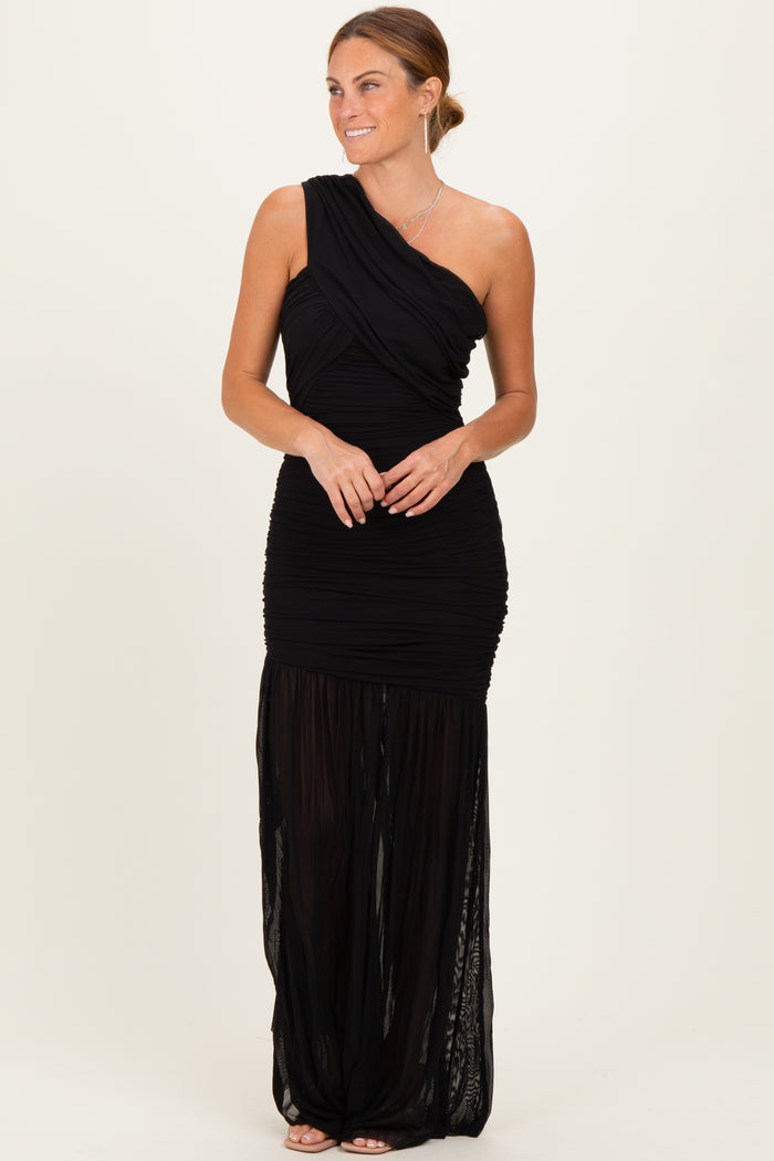 woman wearing a black one-shoulder ruched maxi dress with a sheer skirt detail