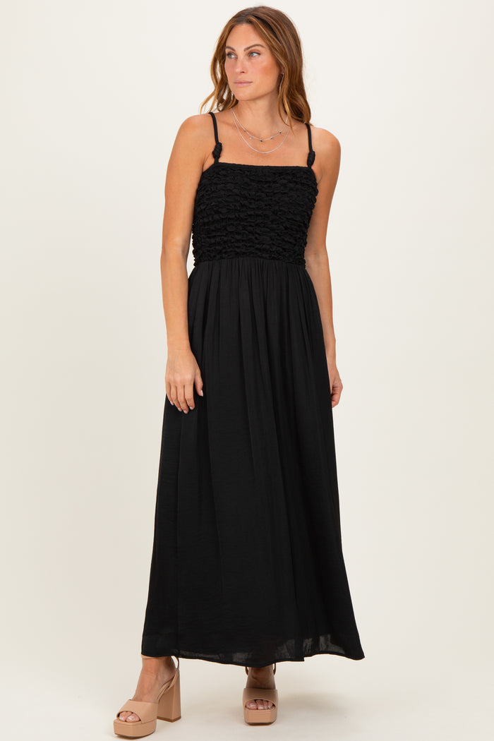woman wearing a black maxi dress with a smocked bodice and adjustable straps