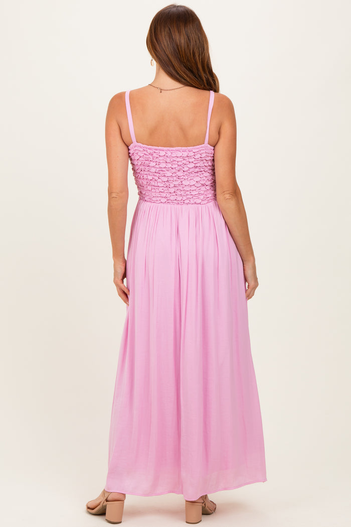 woman wearing a light pink backless maxi dress with a smocked bodice and adjustable straps
