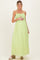woman wearing a light green maternity maxi dress with smocked bodice and holding her baby bump