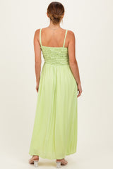 woman wearing a back view of a light green maxi dress with a smocked bodice and adjustable straps