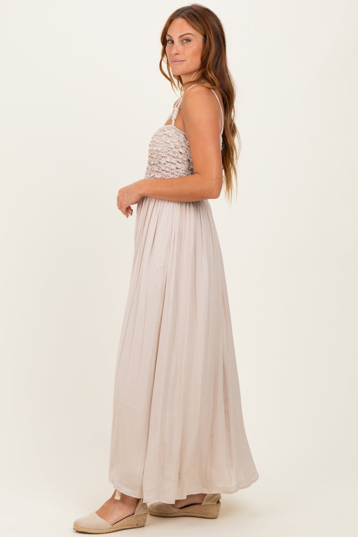 woman wearing a beige halter neck maxi dress with a smocked bodice and flowy skirt, standing sideways