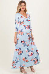 woman wearing a light blue floral maternity maxi dress with a wrap style and a baby bump visible