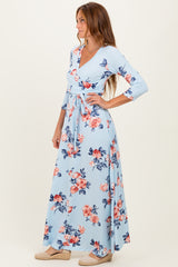 woman wearing a light blue floral maxi dress with long sleeves and a wrap design