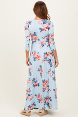 woman wearing a light blue floral maxi dress with three-quarter sleeves, showing the back view