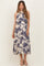woman wearing a floral print maternity dress with a halter neckline and flowing skirt, showcasing her baby bump