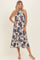 woman wearing a cream floral print midi dress with a halter neck and flowy skirt