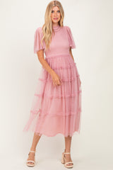 woman wearing a pink tiered tulle midi dress with puff sleeves and a fitted bodice