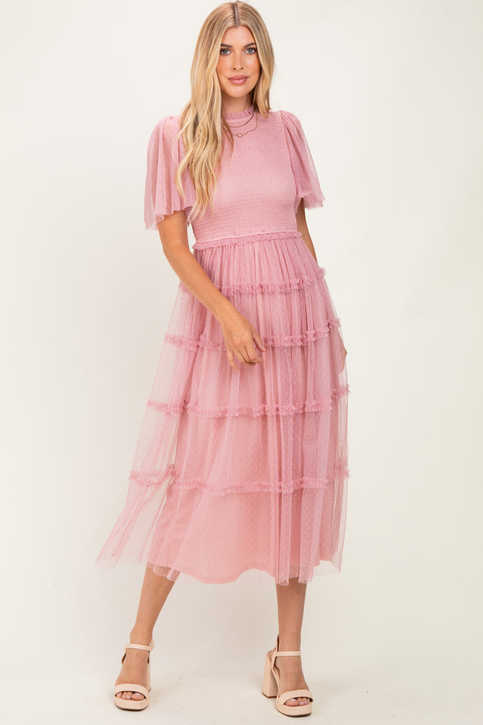 woman wearing a pink tiered tulle midi dress with puff sleeves and a fitted bodice