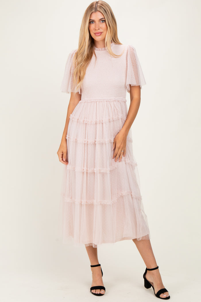woman wearing a pink tiered tulle midi dress with short puff sleeves and a smocked bodice