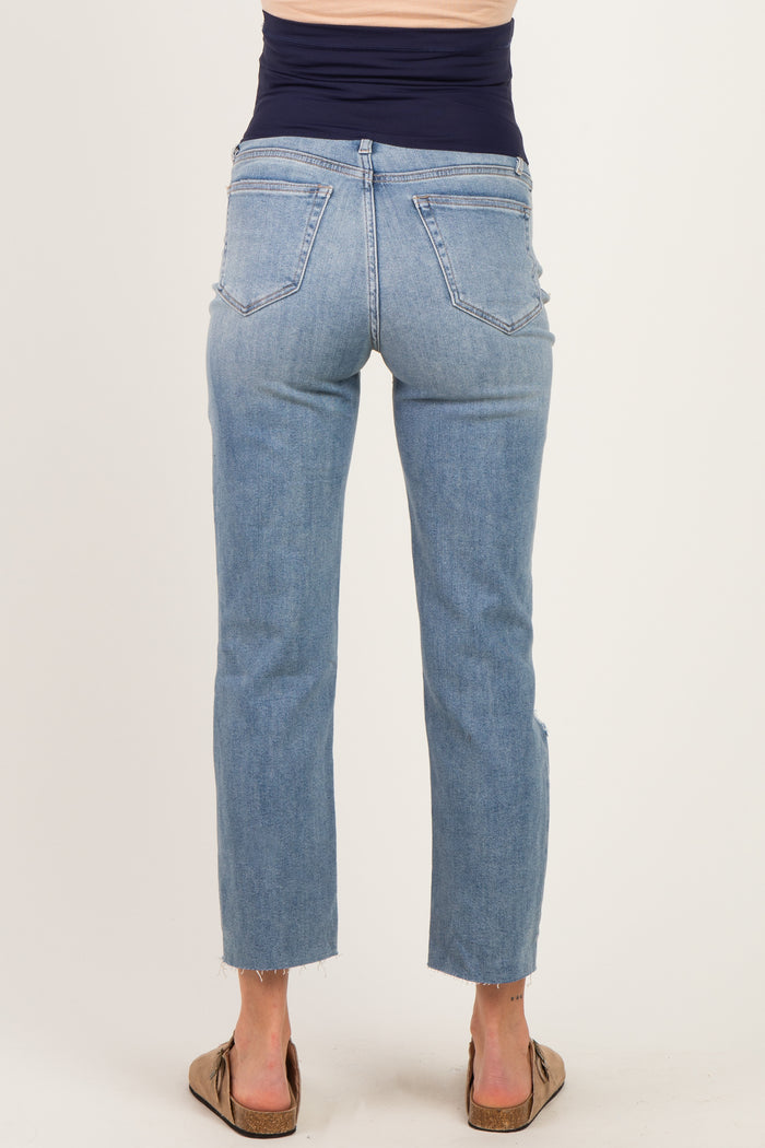 woman wearing light blue maternity jeans with a frayed hem, showing a fitted waistband and back view
