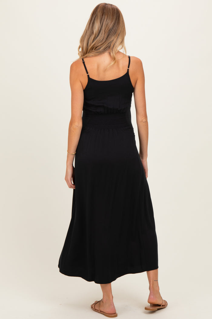 woman wearing a black maternity maxi dress with a smocked waist and adjustable spaghetti straps, showing her back