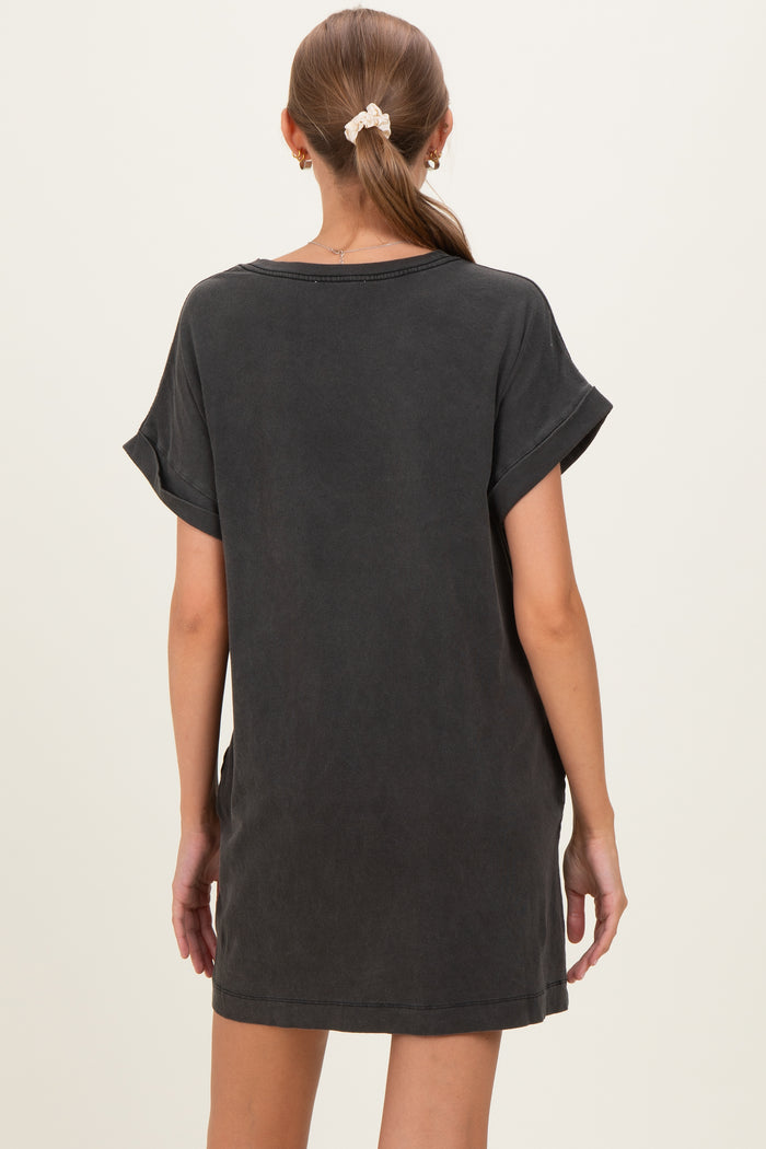 woman wearing a dark gray oversized maternity dress with rolled sleeves