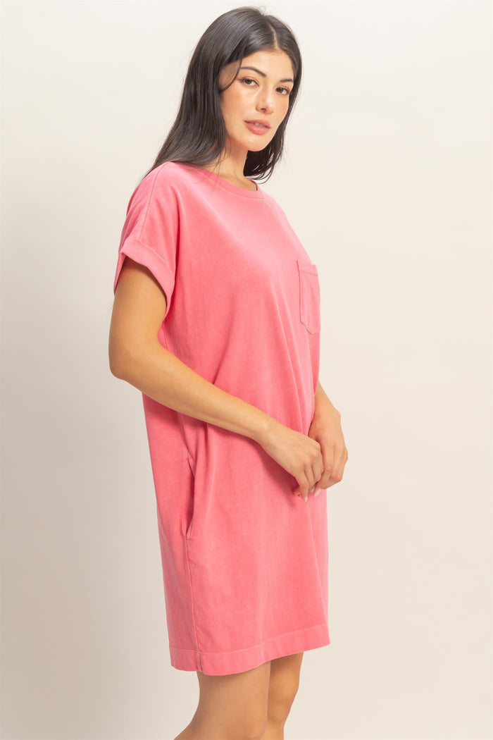 woman wearing a pink short sleeve dress with a front pocket and relaxed fit