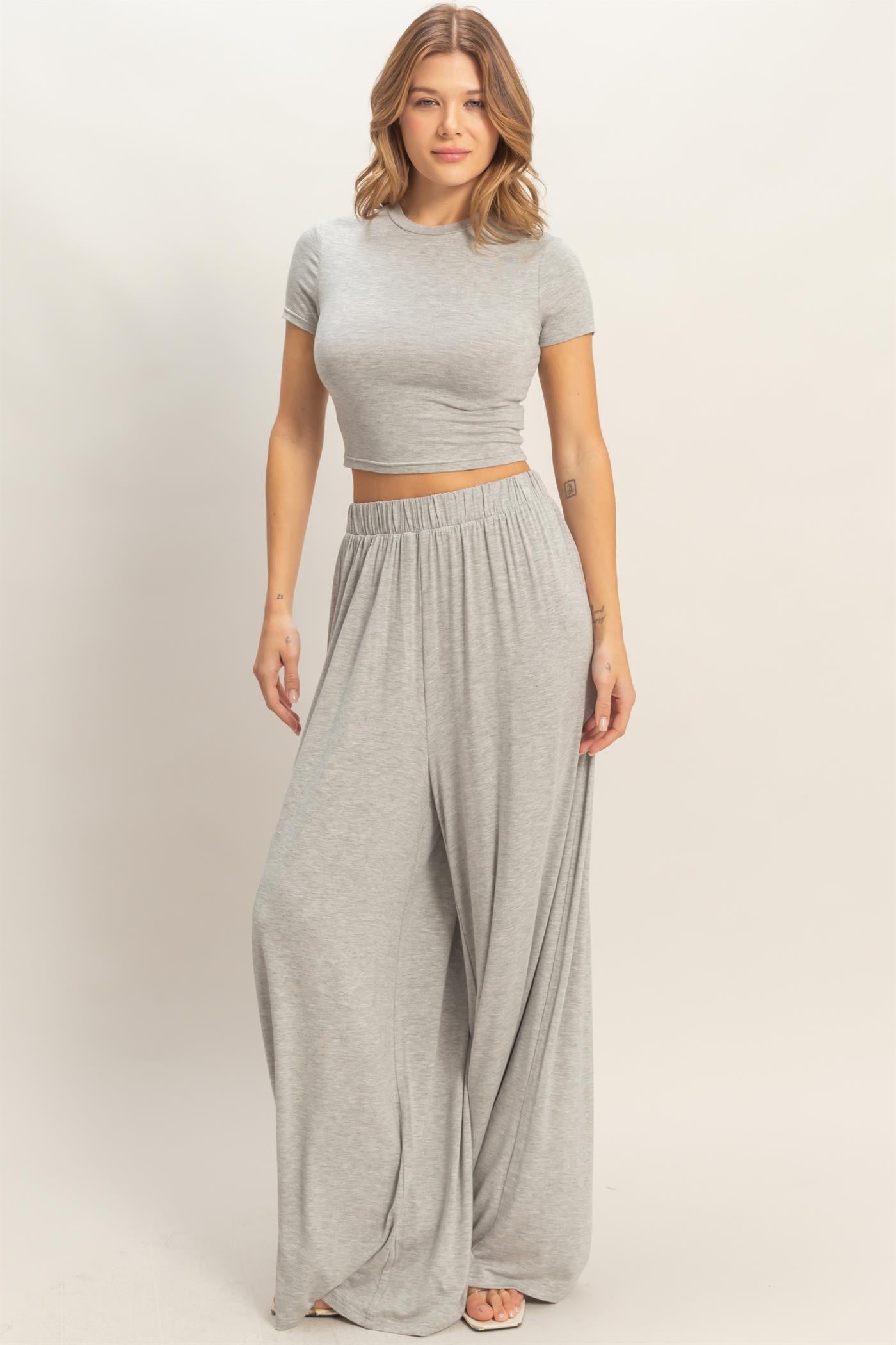 woman wearing a gray cropped t-shirt and matching wide-leg pants in a relaxed fit