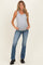 woman wearing a gray ribbed maternity tank top and blue flared jeans, showing her baby bump