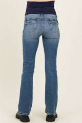 woman wearing light blue maternity jeans from the back with a black waistband and casual footwear