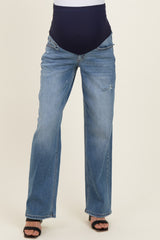 woman wearing light blue maternity jeans with a navy over-the-bump panel and distressed details