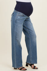 woman wearing light blue maternity wide-leg jeans and showing her baby bump