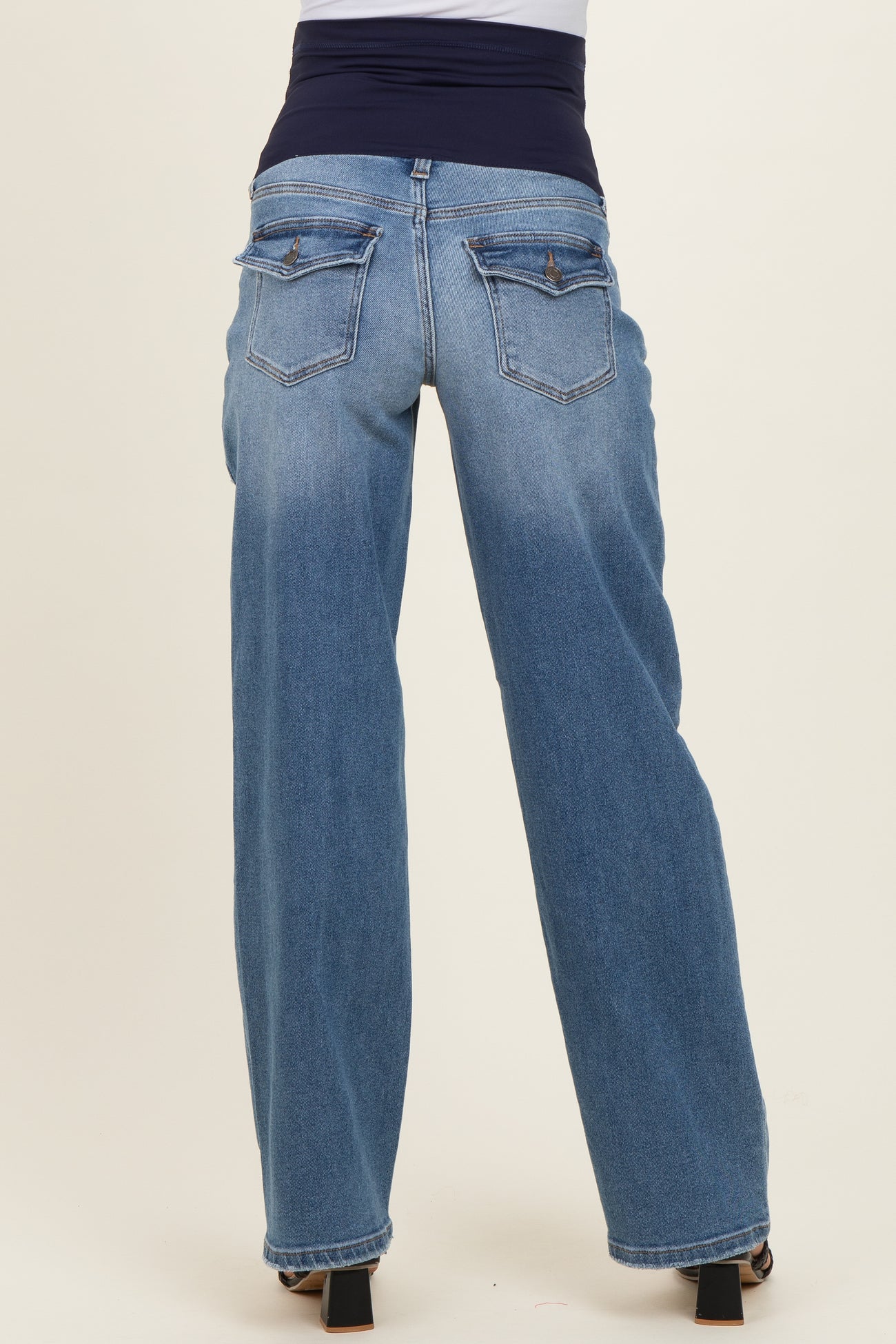 maternity wear light blue wide-leg jeans with a dark blue belly band visible from the back