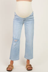 woman wearing light blue maternity jeans with a fitted belly panel and distressed details