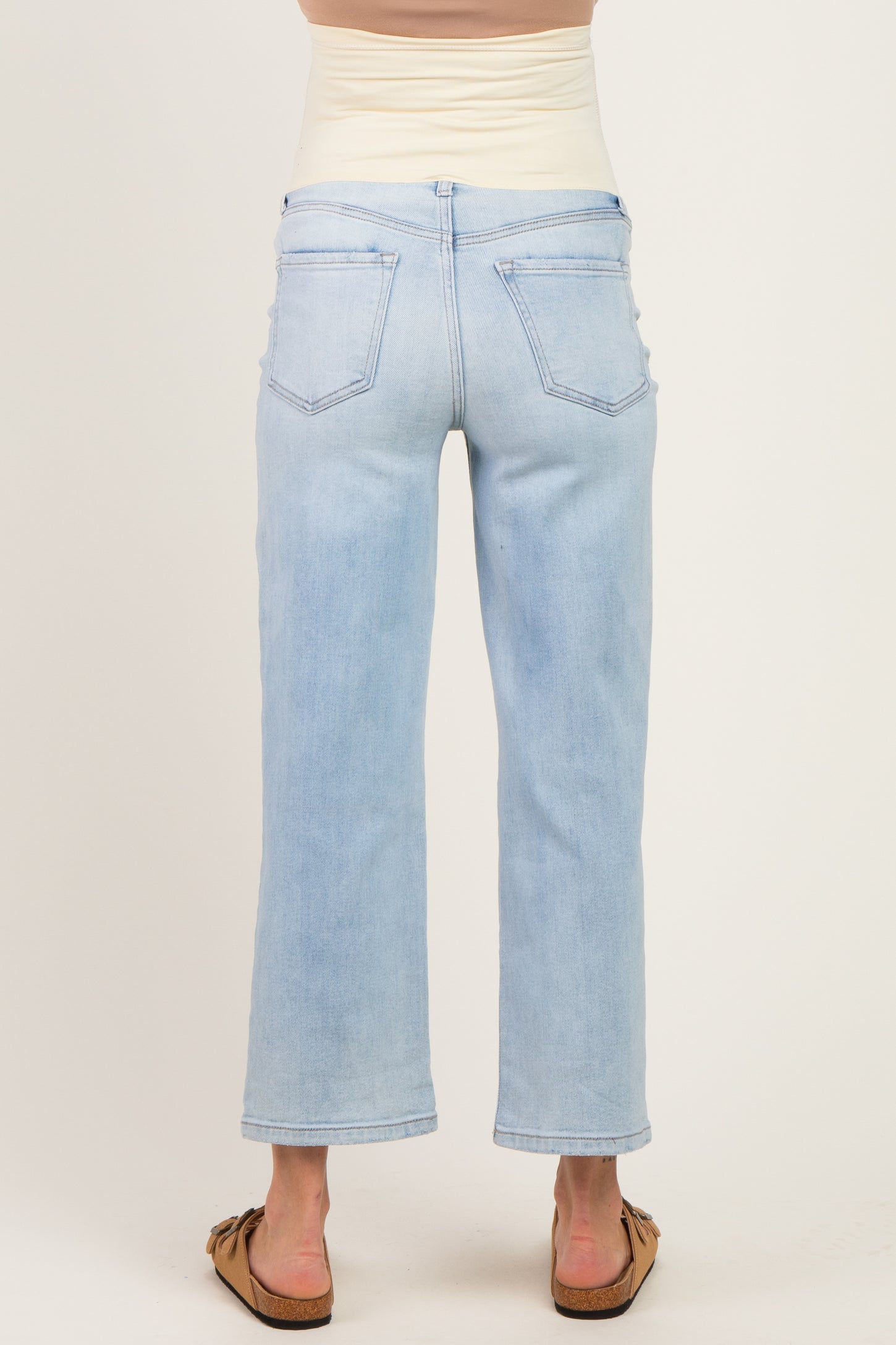 woman wearing light blue maternity jeans with a wide leg and high waistband, viewed from the back
