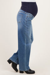 woman wearing light blue maternity jeans with a stretchy waistband, showing a visible baby bump