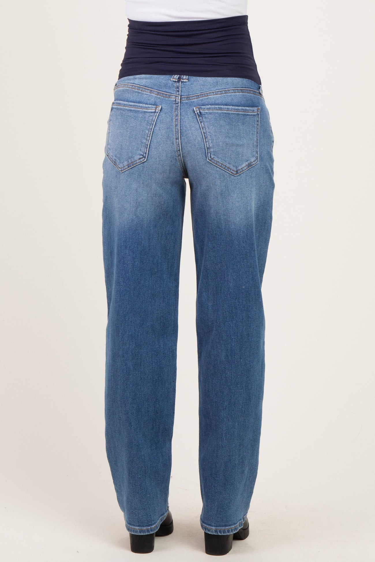 woman wearing light blue maternity jeans with a navy blue waistband, shown from the back