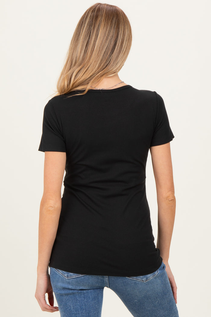 woman wearing a black short sleeve maternity top, viewed from the back with a slim fit silhouette