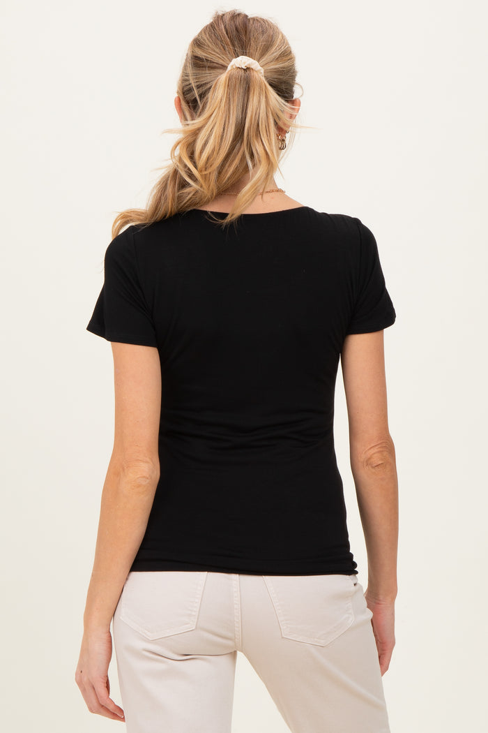 woman wearing a black maternity top viewed from the back, paired with light-colored pants