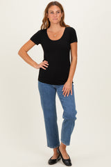 woman wearing a black short sleeve scoop neck top and blue straight leg jeans