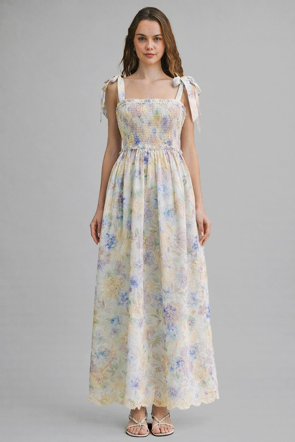 woman wearing a floral maxi dress with smocked bodice and tie shoulder straps
