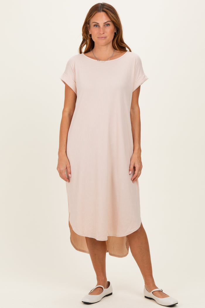 woman wearing a light pink short sleeve midi dress with a hi-low hem and relaxed fit