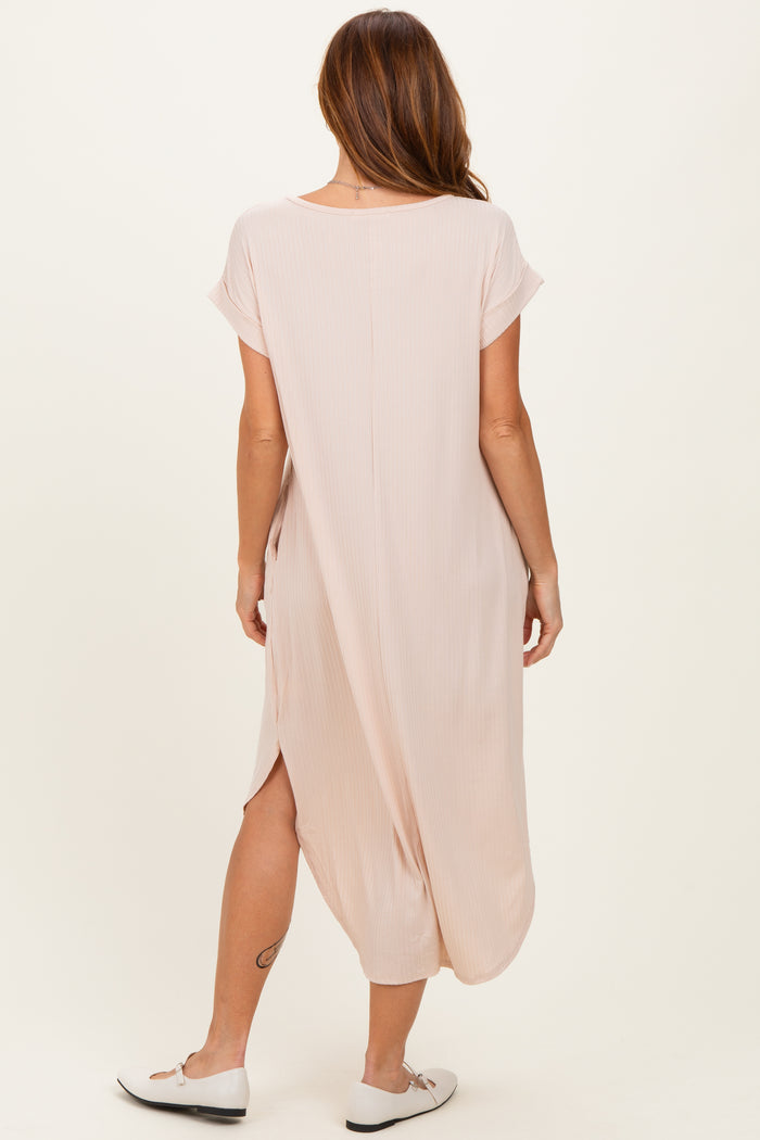 woman wearing a light pink maxi dress with short sleeves and side slits, shown from the back