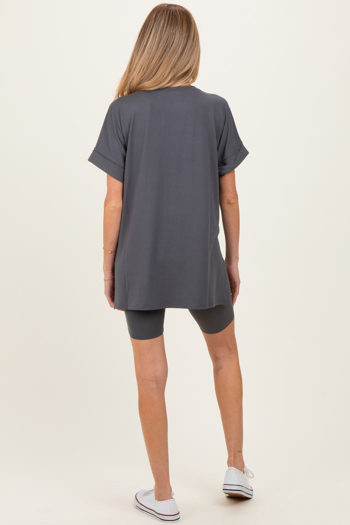 woman wearing a gray maternity tunic top and matching bike shorts, facing away from the camera