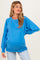 woman wearing a bright blue maternity sweatshirt with a relaxed fit and a visible baby bump