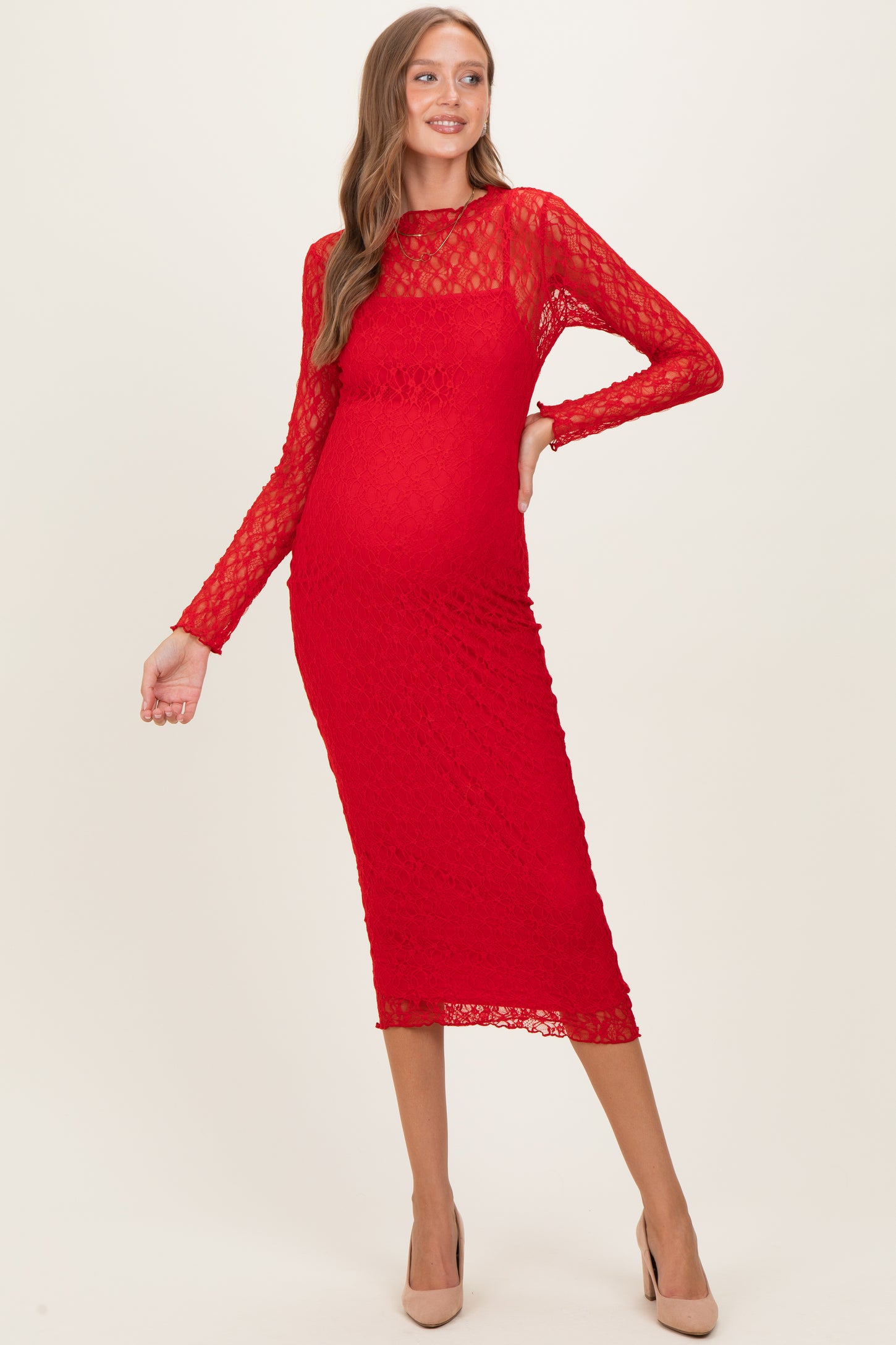woman wearing a red lace long sleeve maternity dress with a fitted silhouette and a visible baby bump