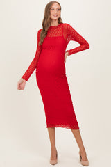 woman wearing a red lace long sleeve maternity dress with a fitted silhouette and a visible baby bump