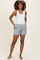 woman wearing a white maternity tank top and blue striped maternity shorts with pockets and drawstring detail
