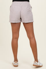 woman wearing striped maternity shorts, showing the back view and paired with white sneakers