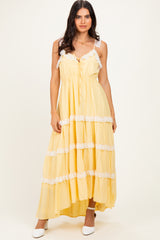 woman wearing a yellow tiered maxi dress with lace trim and adjustable straps