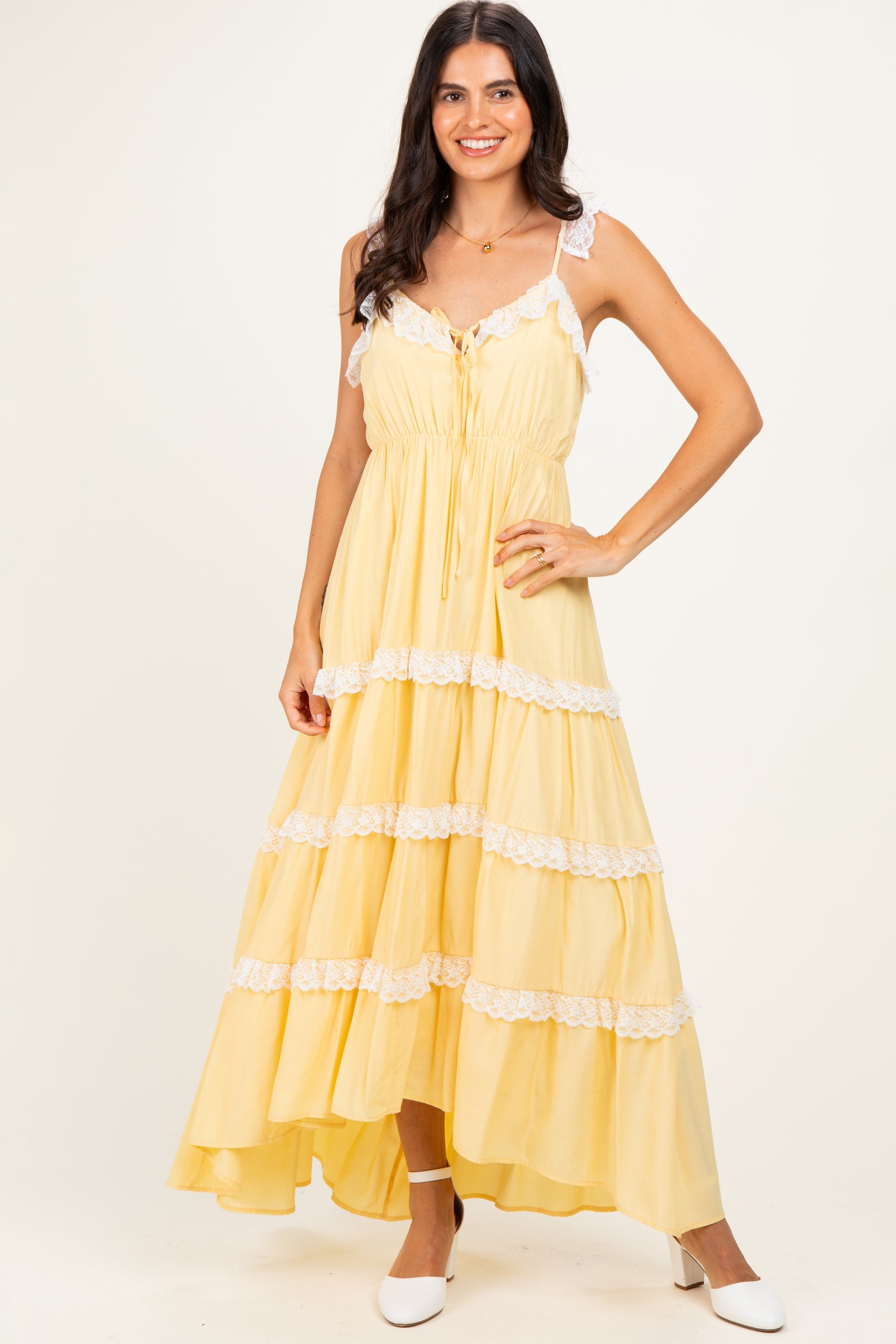 woman wearing a yellow maxi dress with lace details and a high-low hem