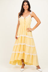 woman wearing a yellow maxi dress with lace details and a high-low hem