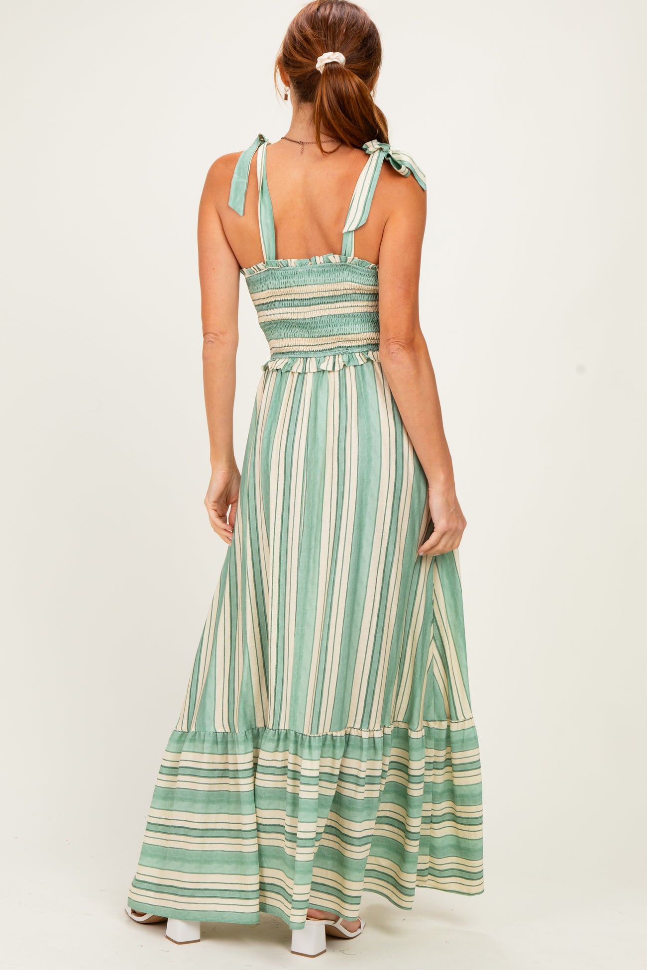woman wearing a green and white striped maxi dress with tie straps and a smocked back detail