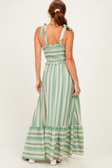 woman wearing a green and white striped maxi dress with tie straps and a smocked back detail