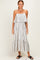 woman wearing a cream and black striped maxi dress with a ruffled tier and spaghetti straps