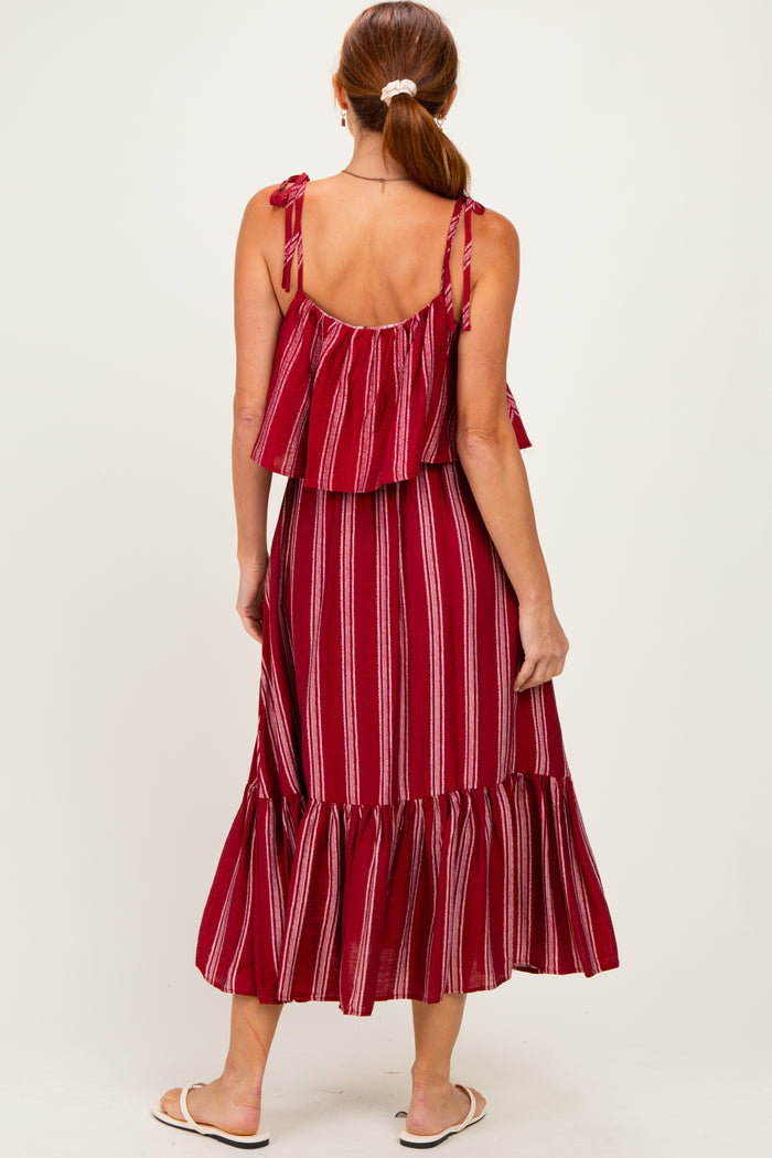 woman wearing a red striped maxi dress with ruffled straps and a tiered hem, shown from the back